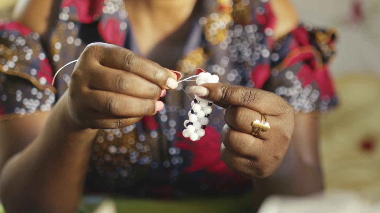 African woman making Traditional Bead accessories 4