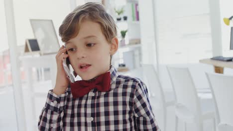 Kid-as-business-executive-talking-on-mobile-phone-4k