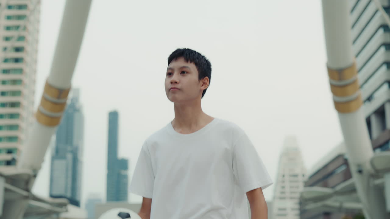 Young man with soccer ball in the city
