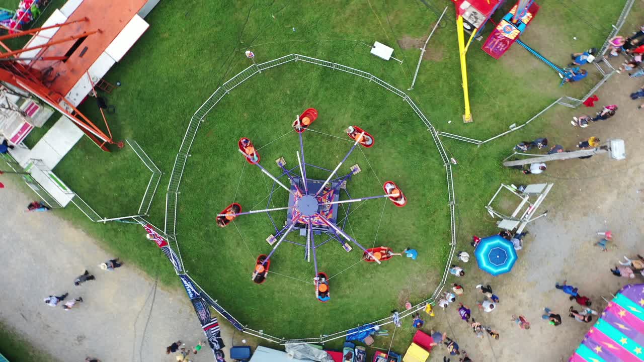 Spiral Down at Amusement Park in West Virginia, USA with funfair rides and people