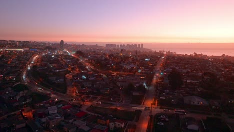 Dolly-En-Vista-Aerea-De-Un-Atardecer-En-Un-Barrio-De-Clase-Baja-Con-Trafico-En-Concon,-Chile