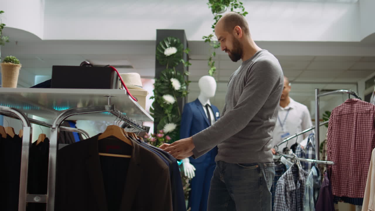 Uomo che acquista abiti in un negozio di abbigliamento maschile