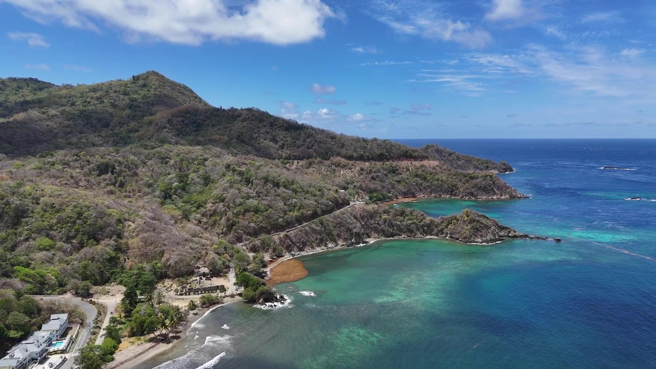 Vista aerea della costa a Speyside, sull'isola di Tobago. Acqua cristallina color turchese e lussureggianti colline tropicali della costa caraibica.