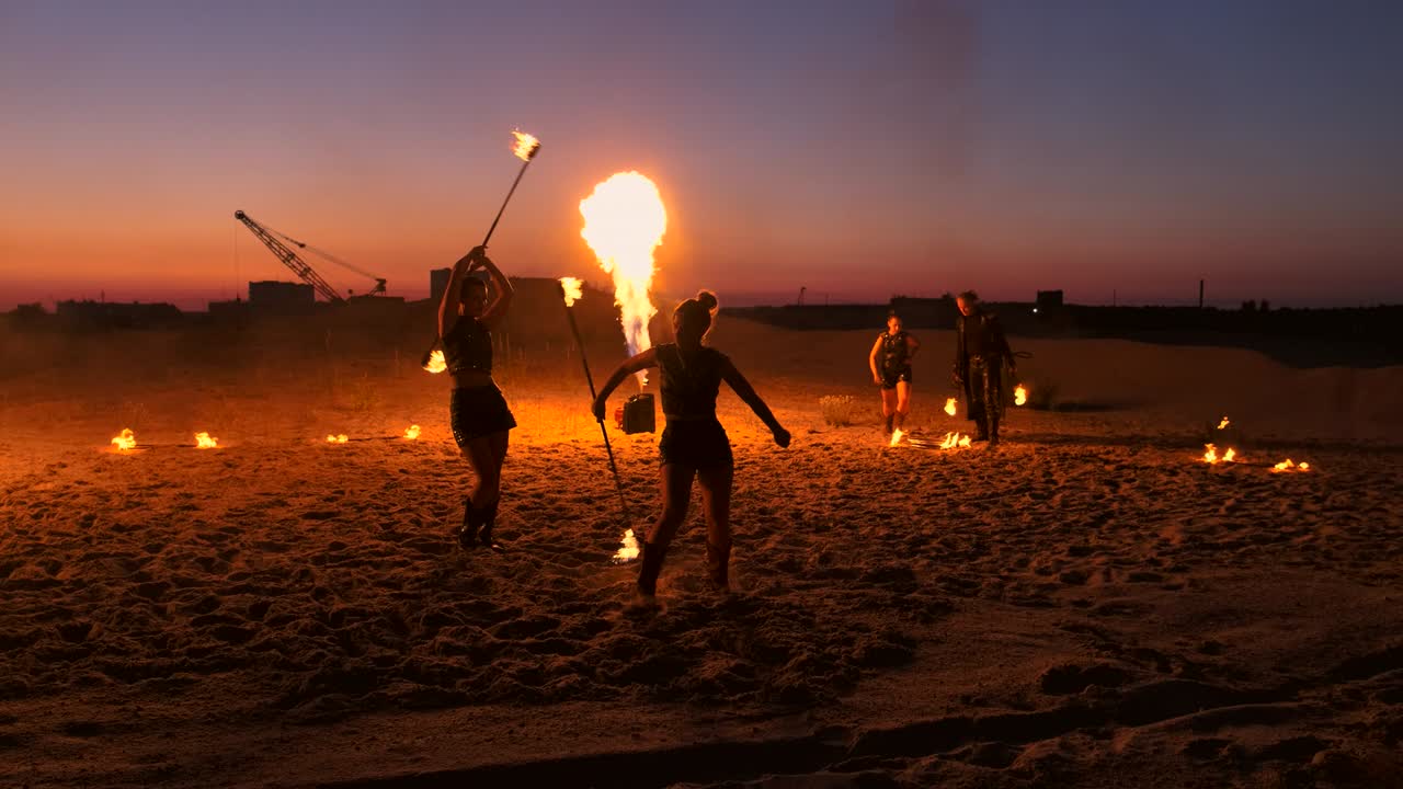전문 예술가들은 여름 축제에서 모래 위에서 느린 동작으로 불 쇼를 보여줍니다. 서커스의 네 번째 사람 아크로바트는 밤에 해변에서 불과 함께 일합니다.