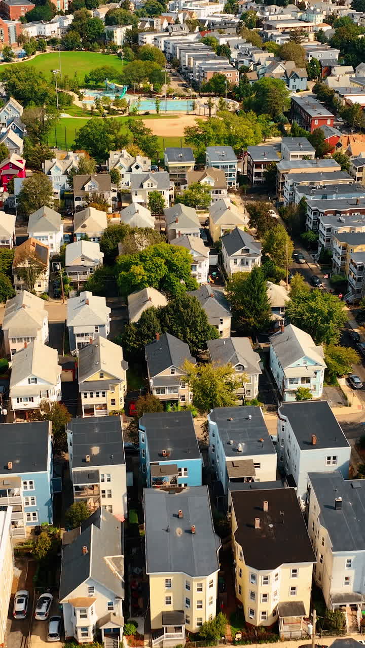 Flight above the rooftops of sunny Cambridge, Massachusetts, USA. Beautiful few-storied houses in the residential area of the city. Vertical video