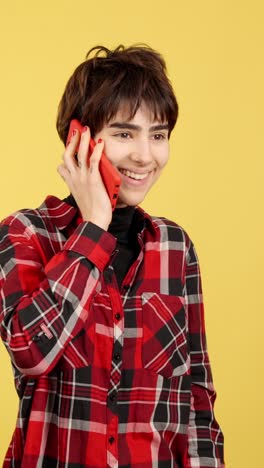 young woman making a phone call, showing various happy expressions on a yellow background