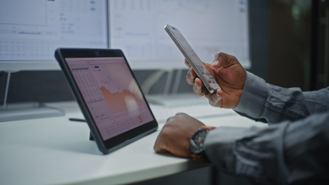 Businessperson reviewing market data on a tablet and smartphone