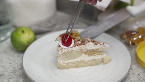 chef places a cherry preparing a dessert recipe