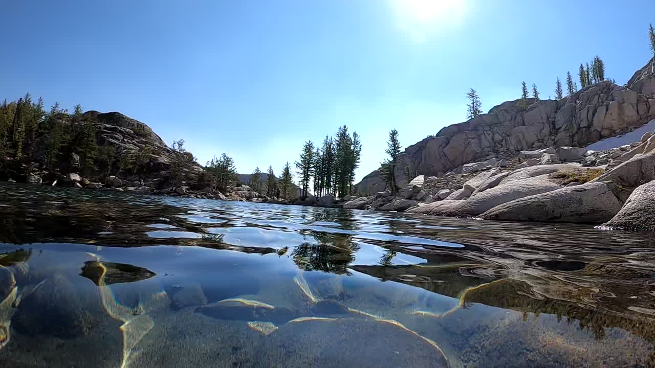 agua cristalina en el lago alpino en un día soleado de verano, buzo pov