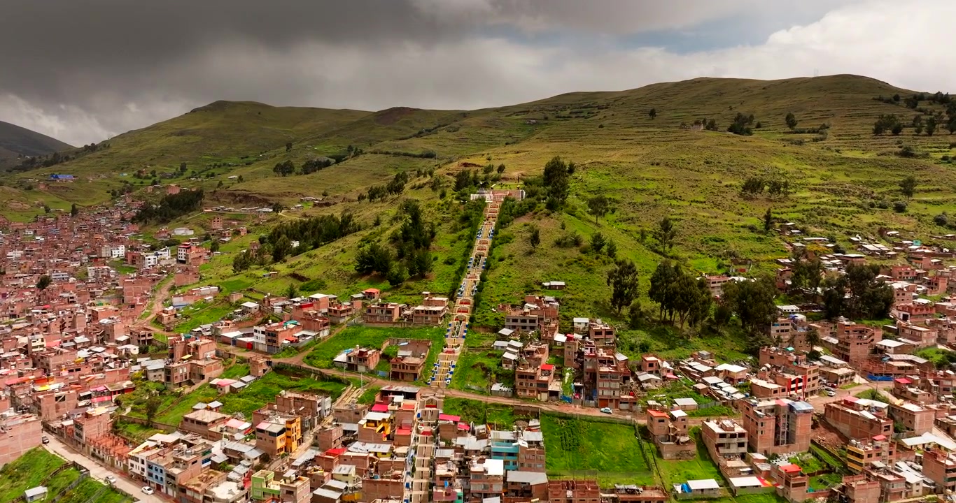 Puno, Perù, che rivela la scalinata per il Mirador de Kuntur Wasi, un punto panoramico di riferimento sulla collina che si affaccia sulla città vicino al Lago Titicaca, vista aerea cinematografica.