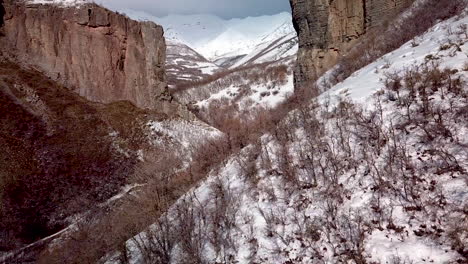 Drone-Vuela-A-Lo-Largo-De-La-Ladera-De-La-Montaña-Hacia-Un-Cañón-Entre-Dos-Acantilados-Escarpados