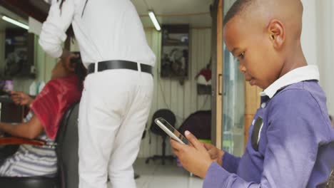 Niño-Africano-Esperando-Mamá-Corte-De-Pelo-En-El-Teléfono