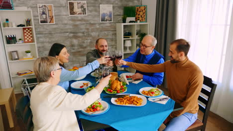 top view of family clinking glasses with red wine