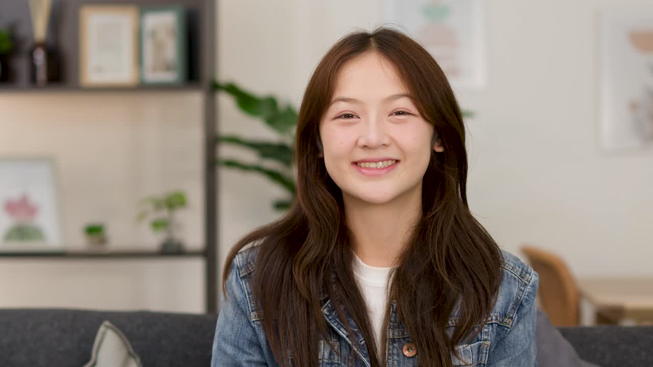 หญิงสาวร่าเริงบนโซฟายกนิ้วชี้ขึ้น แสดงออกถึงไอเดียที่เกิดขึ้นอย่างกะทันหันในห้องนั่งเล่นที่สว่างสดใส