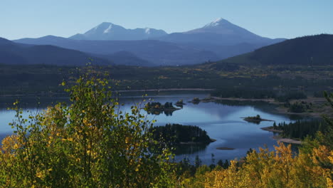 early fall colors aspen trees lake dillon islands colorado aerial cinematic drone morning view frisco breckenridge silverthorne ten mile range calm reflective water yellow dolly jib upward movement