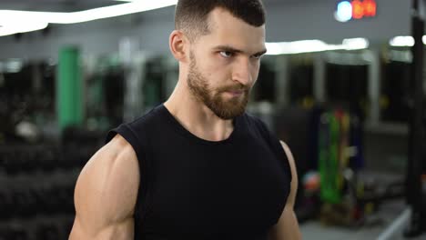 Portrait-of-muscular-athlete-works-out-with-dumbbells