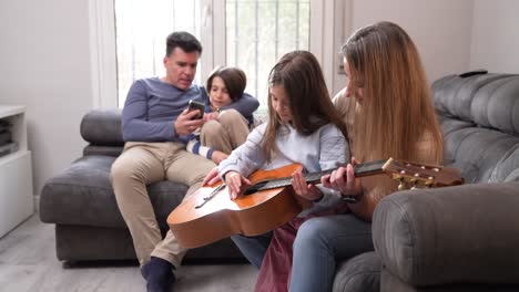 a family learning to play guitar together in their living room