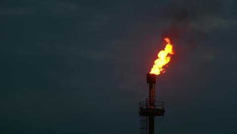 Burning-flame-in-top-of-tower-in-oil-rig-in-Pakistan,-pollution-in-Asia