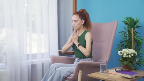 christian woman praying in front of the window.