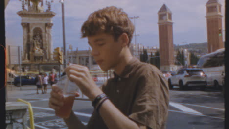 young man enjoying a drink on a summer day