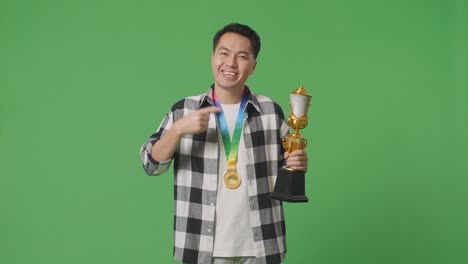 hombre con un trofeo y una medalla