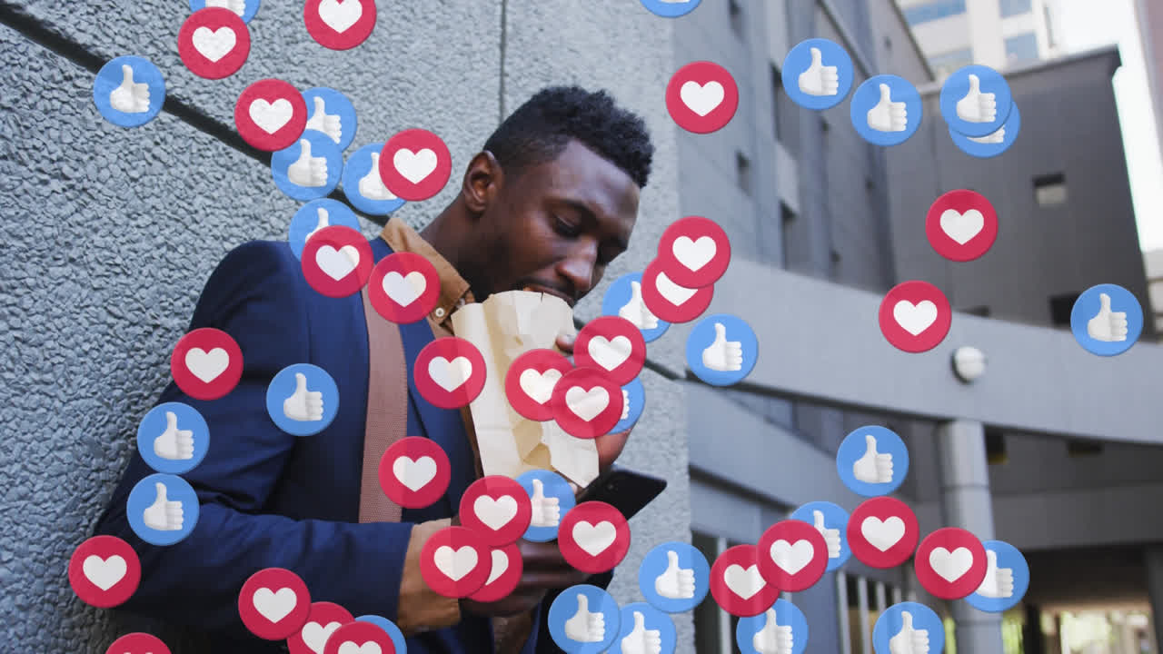 Multiple social media icons against african american man having a snack while using smartphone