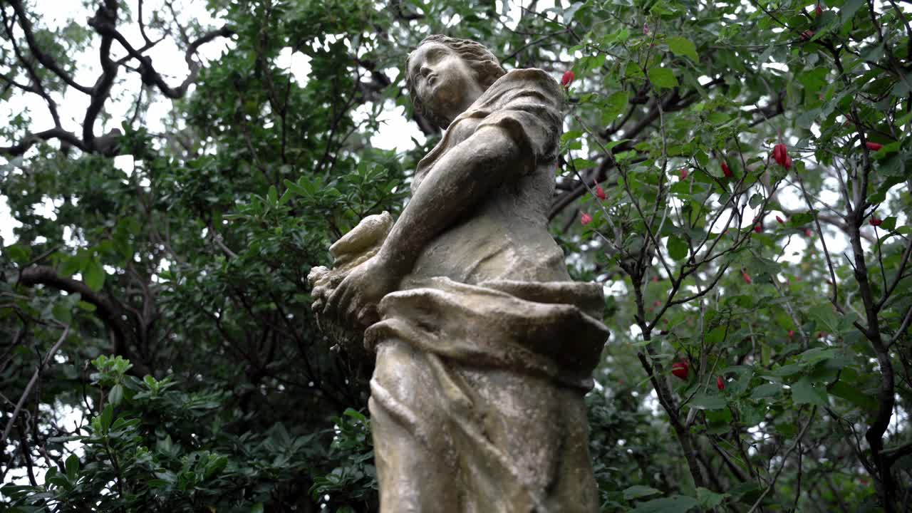 Statua di una donna tra gli alberi