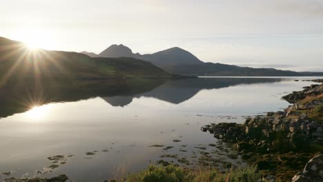 A-golden-sunburst-reflects-off-of-the-still-surface-of-a-tidal-sea-loch-