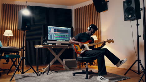 a musician playing bass guitar in a recording studio