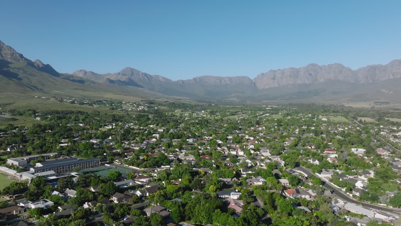 은 파란 하늘 아래 산을 배경으로 한 초록색 주거 지역, 공중 사진
