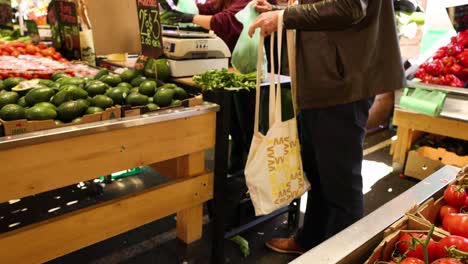 person selecting vegetables at market stall