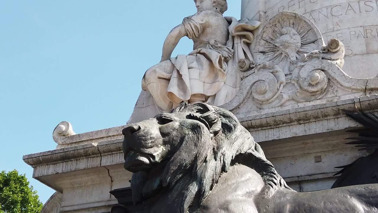 Primo piano che mostra le sculture in pietra del Monumento alla Repubblica e la statua del leone in Place de la Republique a Parigi. Scultura storica dettagliata, simbolismo e maestria artigianale sotto la luce del giorno