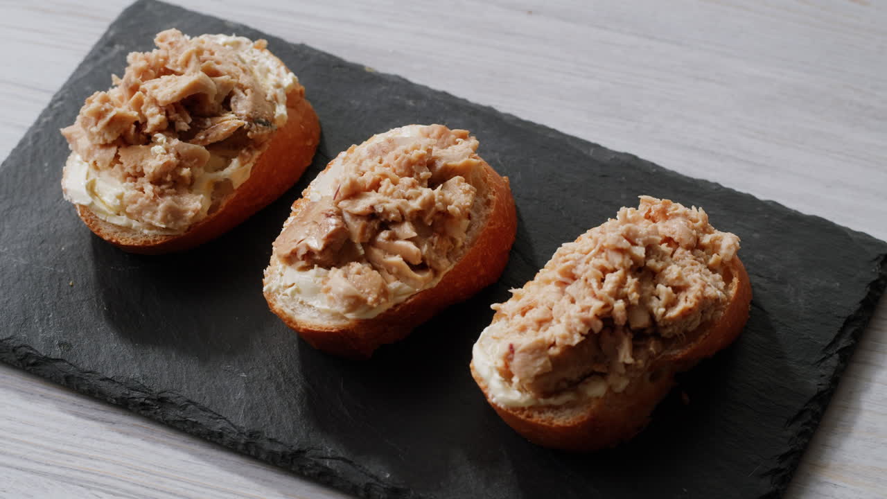 Smoked cod liver in oil in open tin can with fresh greens on wooden table. Seafoods delicacy. High quality 4k footage
