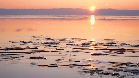 experimente una serena puesta de sol sobre el lago congelado baikal mientras las capas de hielo fluyen suavemente a través de la superficie, creando una vista pintoresca de la belleza de la naturaleza al atardecer.