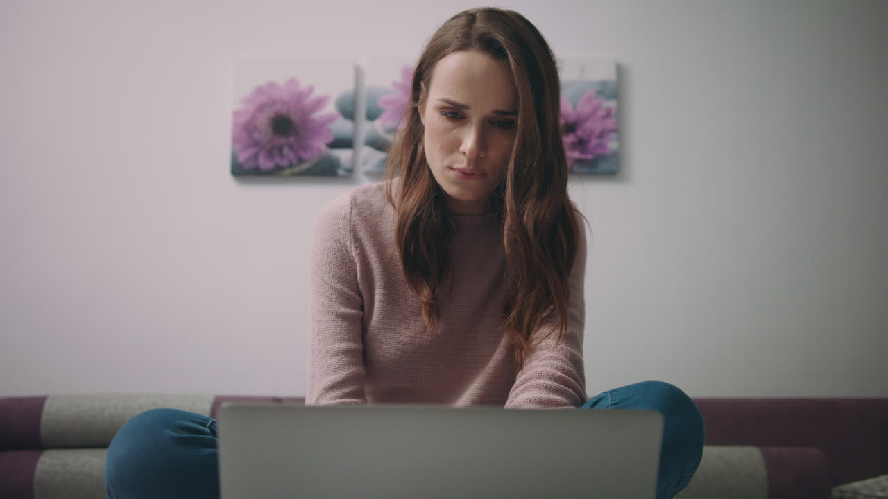 mujer seria buscando citas en línea en la computadora portátil. educación en línea en casa