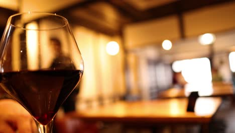 primer plano de una copa de vino rojo en un entorno cálido