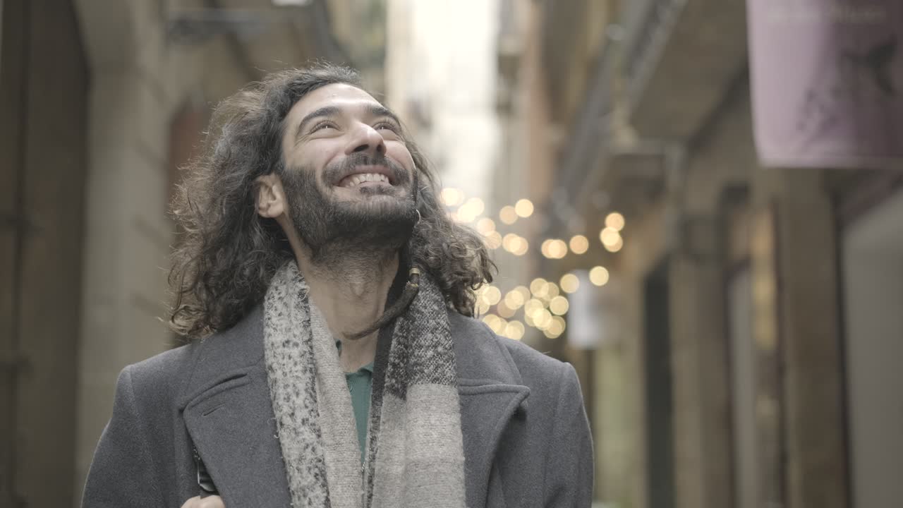 Man in coat and scarf in city street