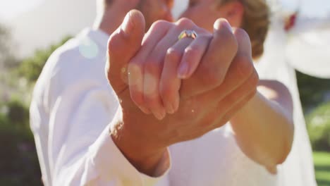 retrato de una feliz pareja de recién casados caucásicos, bailando frente al altar al aire libre