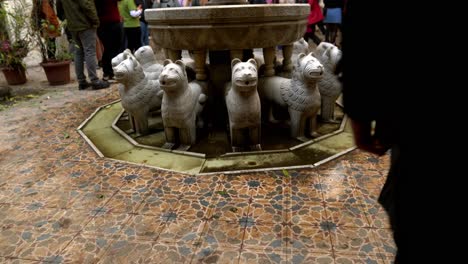 tilt up of the main lion fountain of the luxurious but neglected alhambra palace full of tourists, santiago, chile