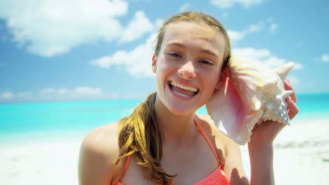portrait of girl on beach holding conch shell