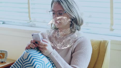 Animation-of-digital-globe-of-connections-over-woman-using-smartphone