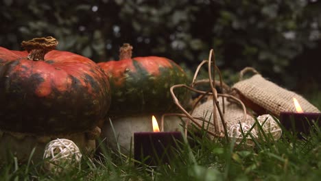 autumnal background with pumpkins and candles with flames moving in the wind