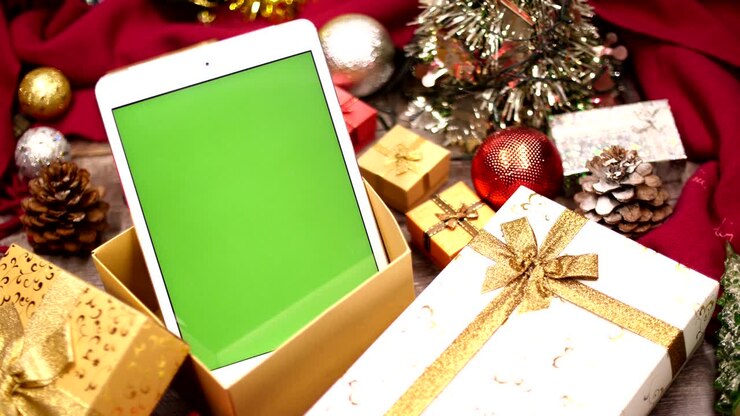 tablette avec écran vert et décoration de noël sur la table.