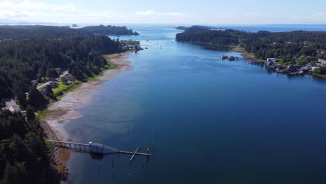 ucluelet british columbia harbour, a drone flies over the bay water showing ucluelet in the background