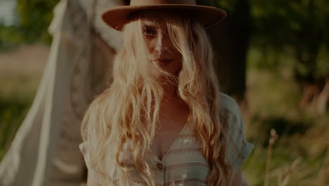 portrait of charming woman in hat looking straight to camera