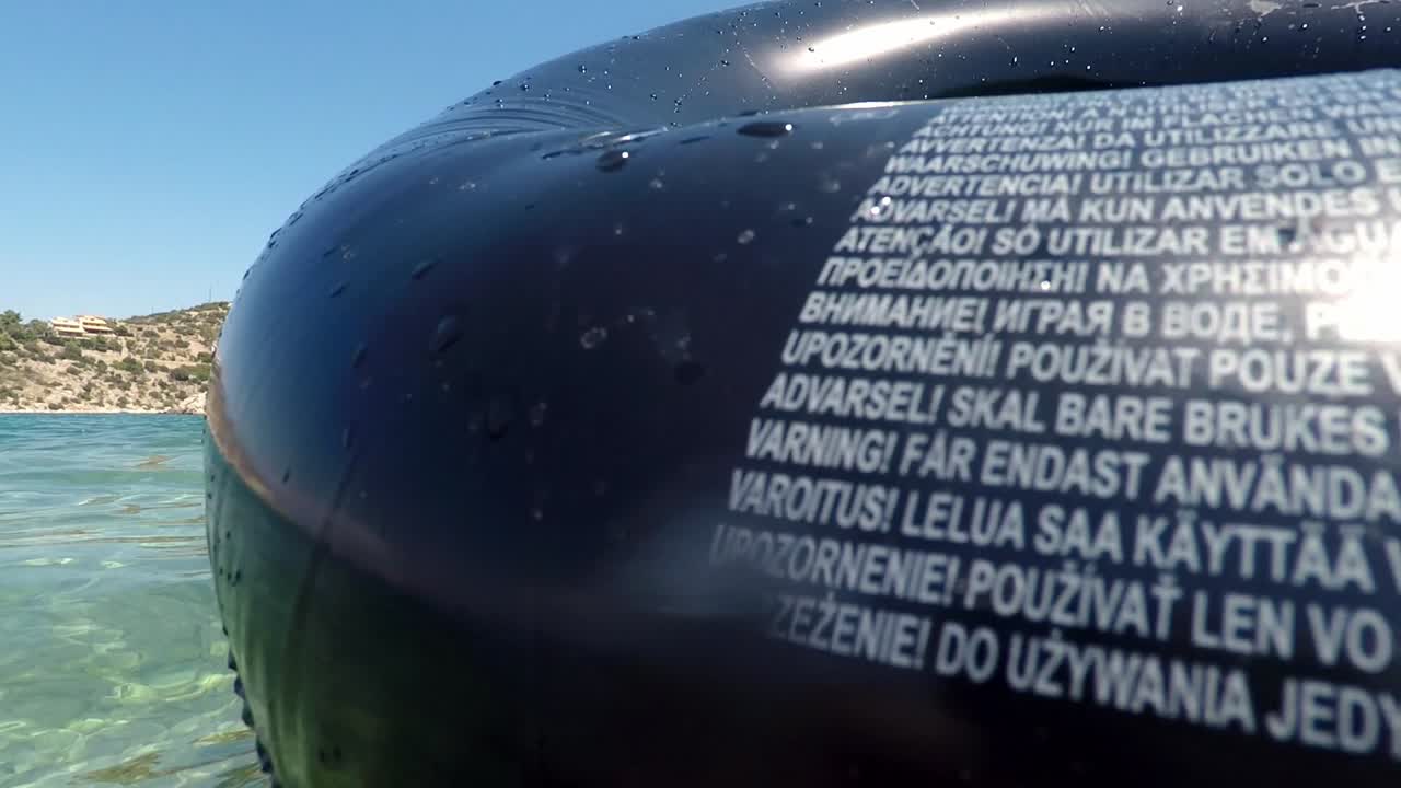 백인 아이의 슬로우 모션, 바다를 즐기고, 부풀릴 수 있는 수영 튜브를 가지고 놀고, 슬로우 모션 샷