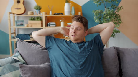 man stretching on a couch at home