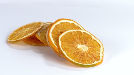 dried thin orange slices against white background