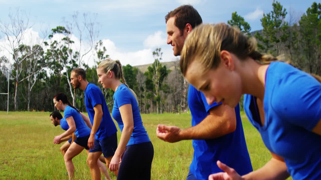 personas en forma corriendo en el campamento de entrenamiento 4k