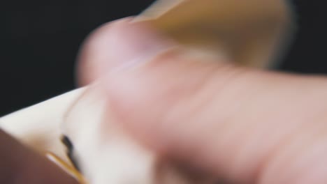 man cleans dirty glasses with light cloth on dark background